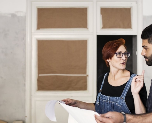 Couple consultant les plans et documents pour leur projet de rénovation de toiture