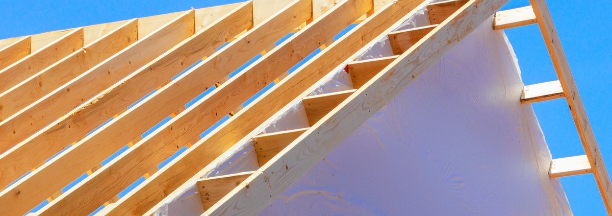Charpente bois avec chevrons et écran sous-toiture visible lors d'un chantier d'isolation par l'extérieur