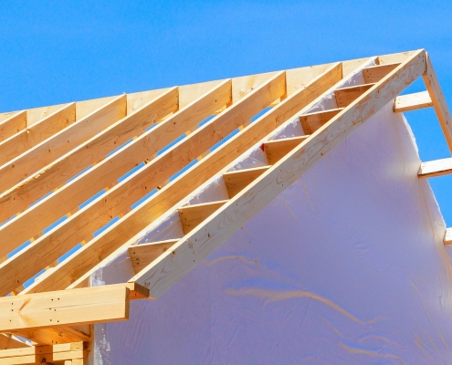 Charpente bois avec chevrons et écran sous-toiture visible lors d'un chantier d'isolation par l'extérieur